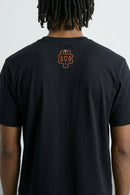Person wearing a black t-shirt with a logo on the back against a light background
