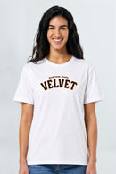 Woman wearing a white t-shirt with 'Velvet' printed on it against a plain background
