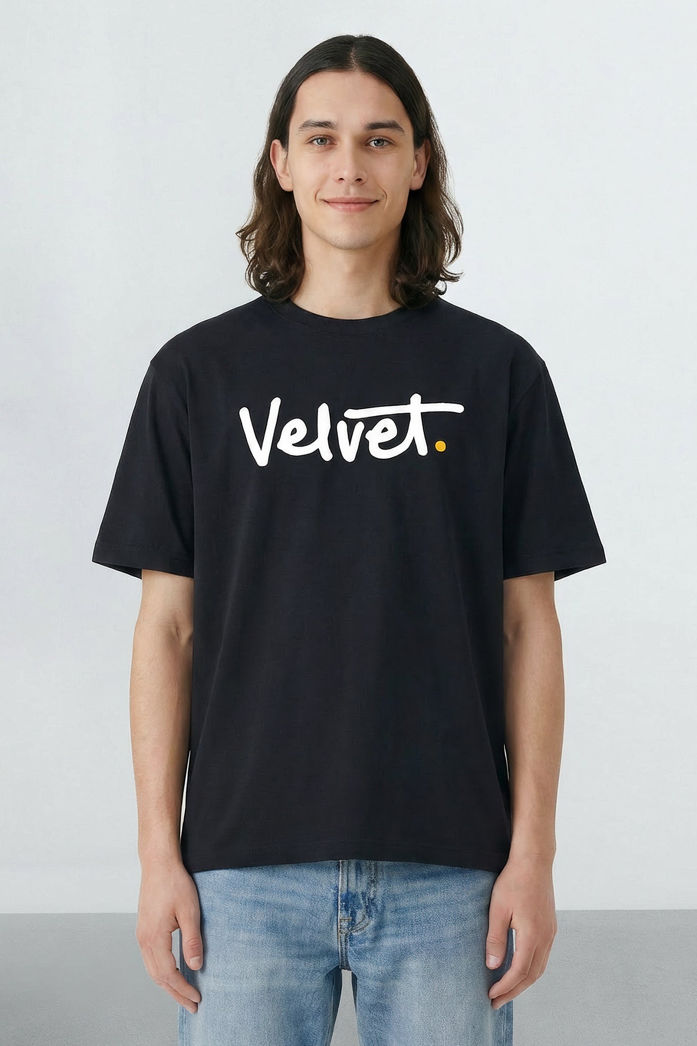 Person wearing a black t-shirt with 'Velvet' logo on a light background