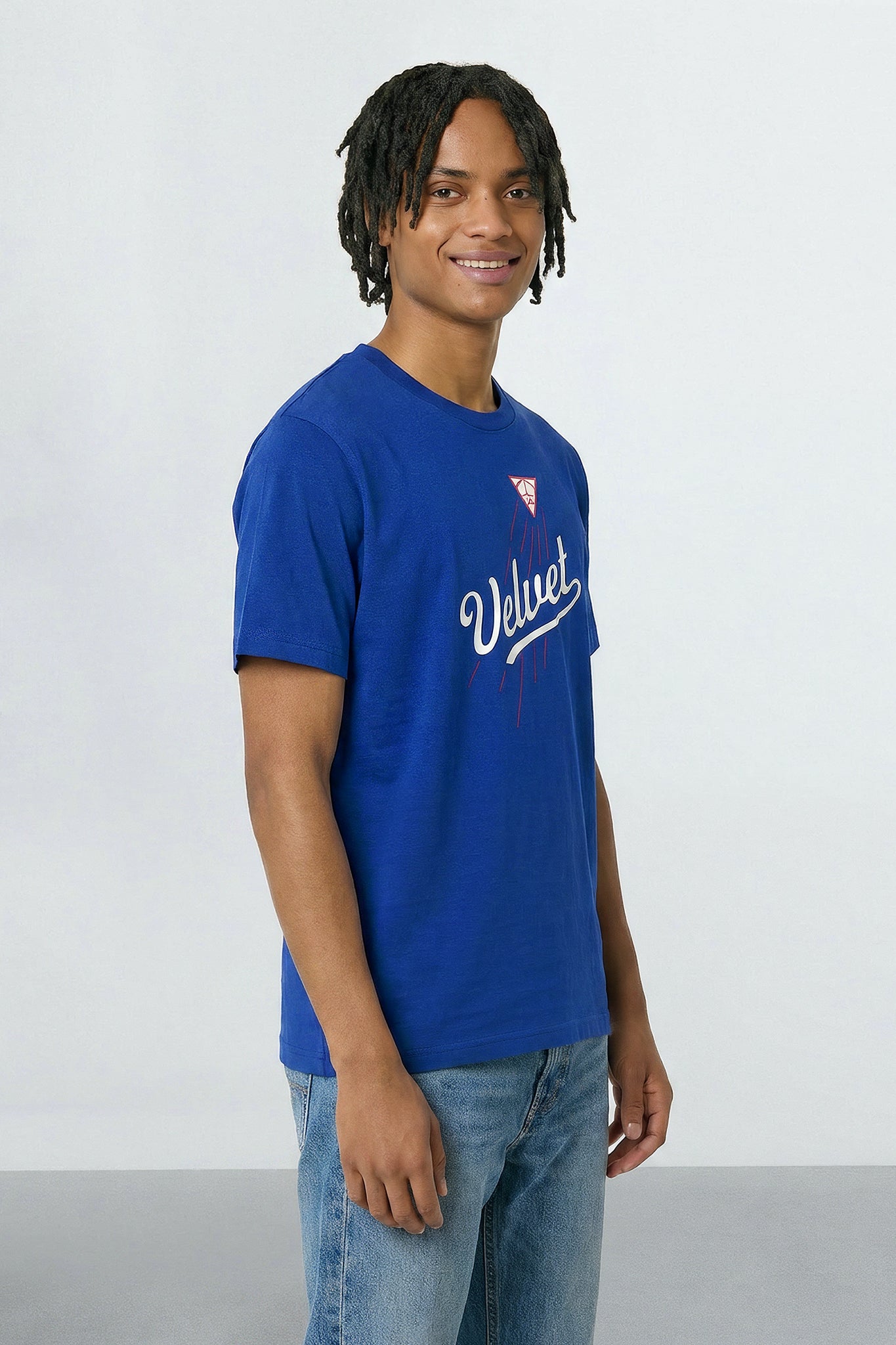 Person wearing a blue t-shirt with a logo and text on a plain background