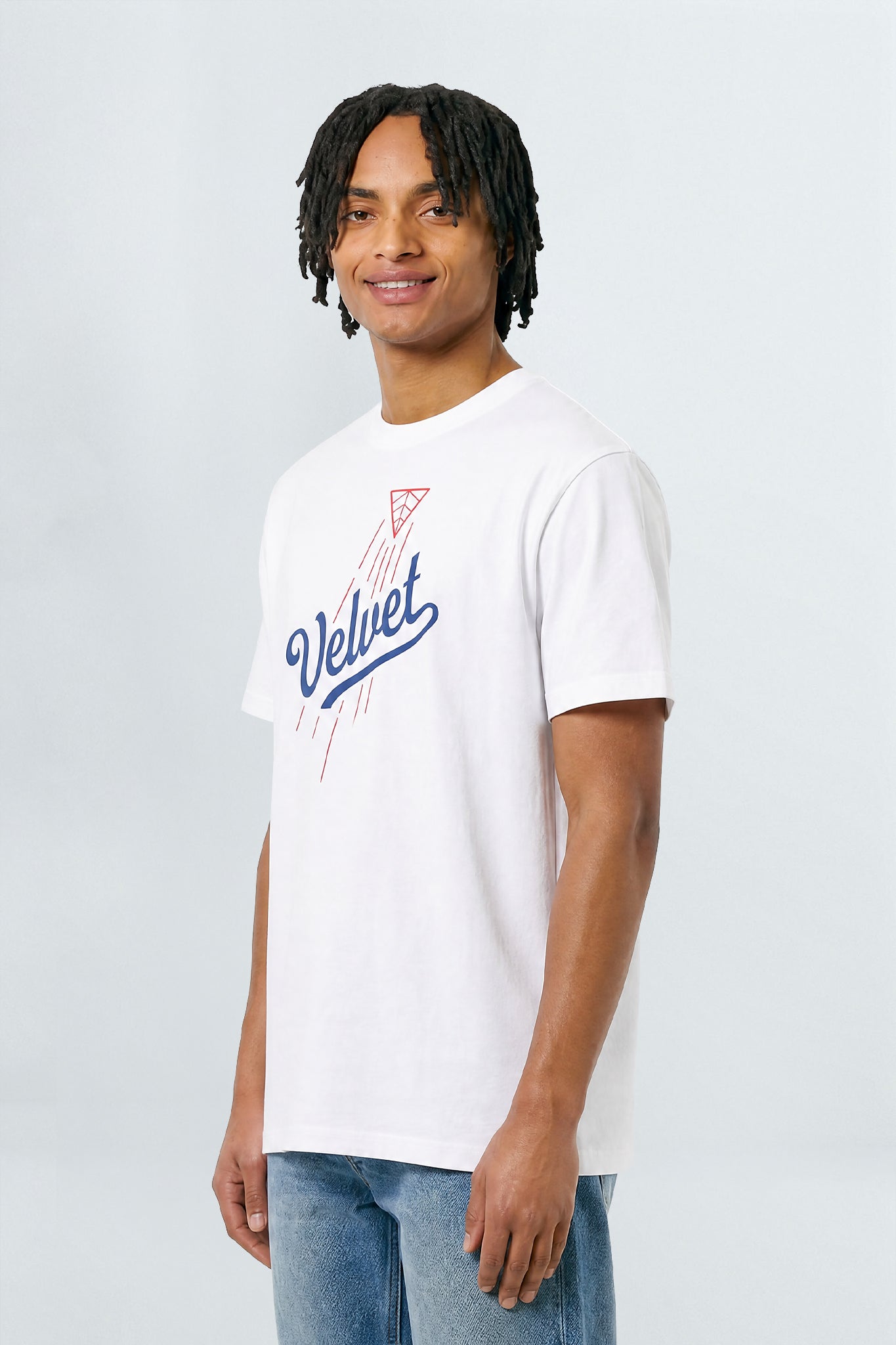 Person wearing a white t-shirt with a logo and text on a plain background